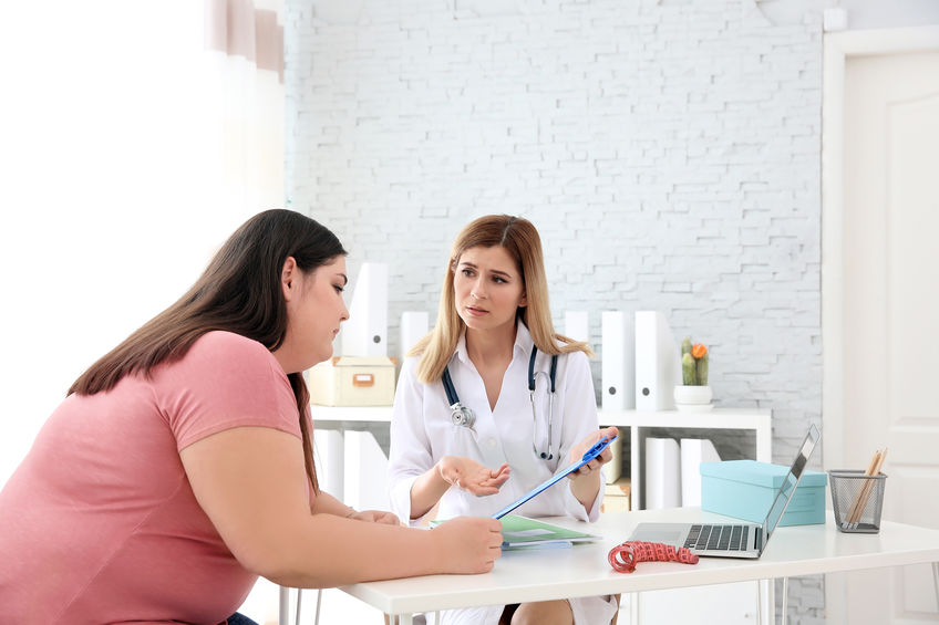 Female doctor consulting overweight woman in clinic