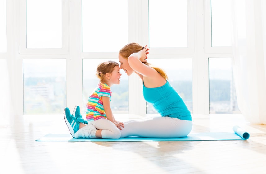 family mother and child daughter are engaged in fitness, yoga, exercise at home