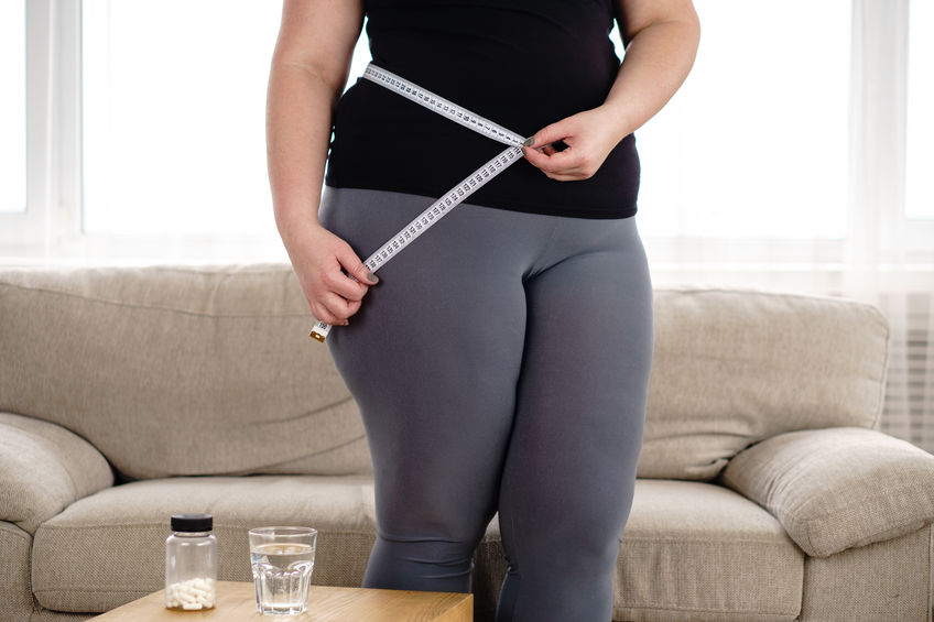 weight loss, medical therapy, diabetes prevention. Fat obese woman with pills and measure tape