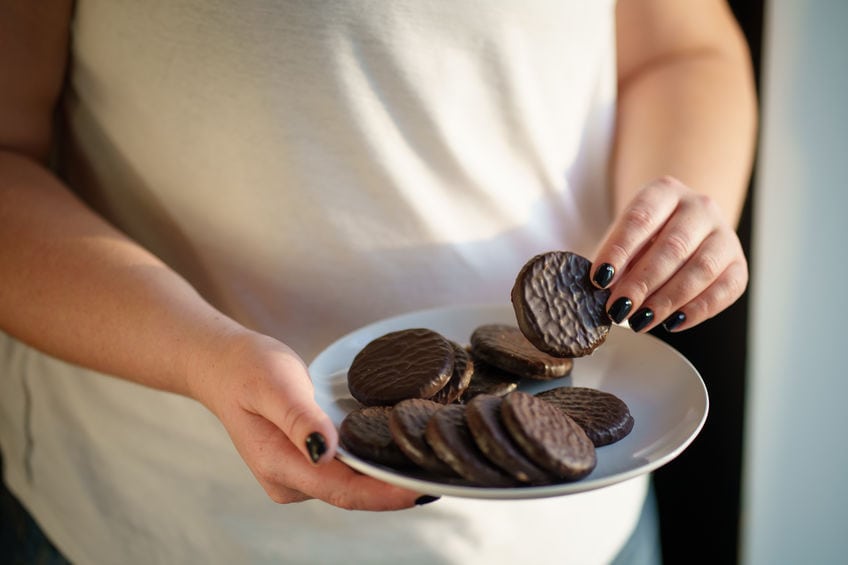 cheat meal, unhealthy eating, imbalanced nutrition, snacking, diet breakdown, weight loss. overweight woman eating chocolate cookies